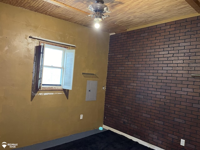 empty room with ceiling fan, electric panel, and wood ceiling