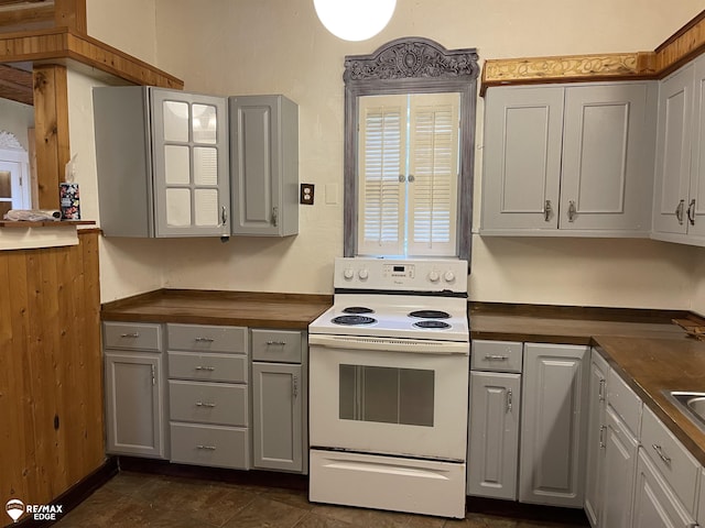 kitchen featuring white range with electric cooktop, gray cabinetry, and butcher block countertops