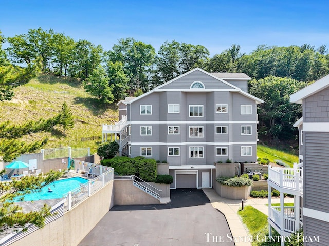 810 S Harbor Dr Unit 21, Grand Haven, MI 49417 - view of front of house featuring a garage, asphalt driveway, and a community pool