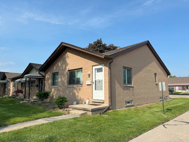 view of front of home with a front lawn and brick siding