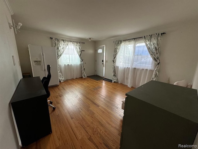 office space with wood finished floors, a healthy amount of sunlight, and ornamental molding