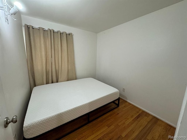 bedroom featuring wood finished floors and baseboards