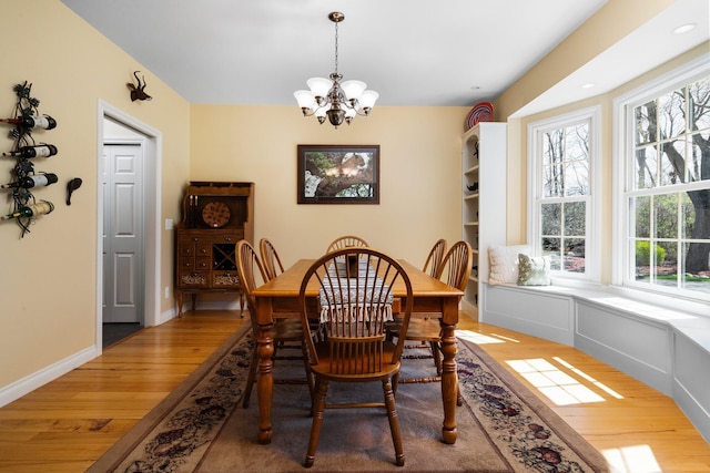 dining space with a chandelier, wood finished floors, and baseboards