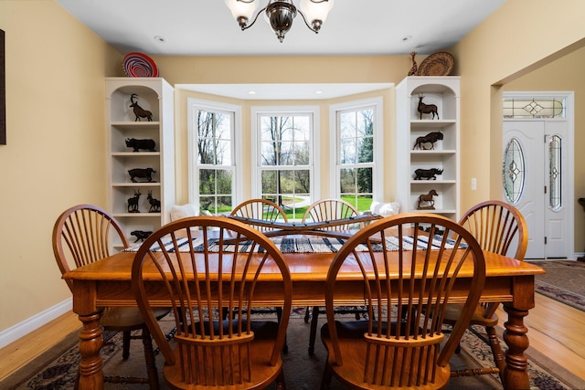 dining room featuring an inviting chandelier, wood finished floors, and baseboards