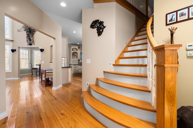 stairway featuring hardwood / wood-style floors, baseboards, and recessed lighting