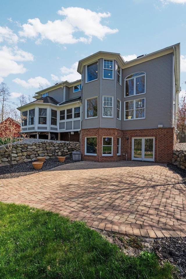 rear view of house featuring a patio area and brick siding
