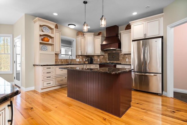 kitchen featuring decorative backsplash, freestanding refrigerator, open shelves, custom range hood, and light wood finished floors
