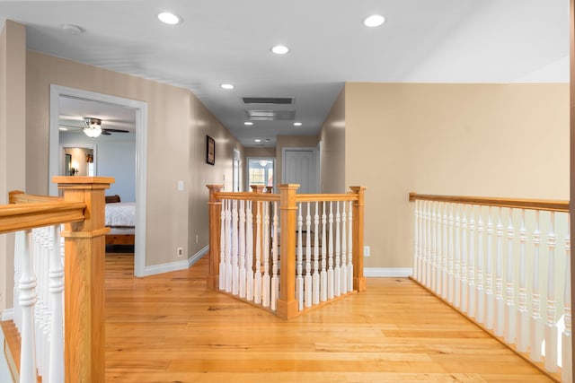 hall featuring an upstairs landing, visible vents, baseboards, recessed lighting, and wood finished floors