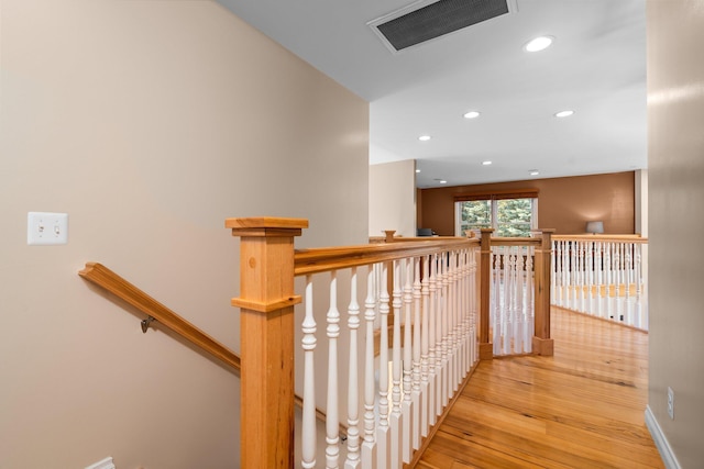 stairs with recessed lighting, visible vents, hardwood / wood-style flooring, and baseboards