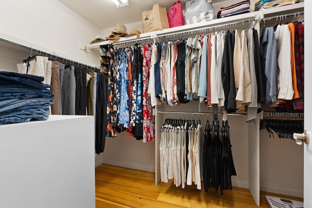 walk in closet with wood finished floors