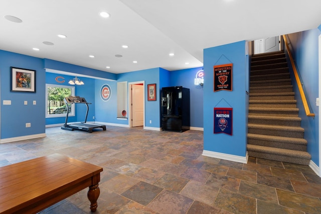 living area featuring baseboards, stairway, stone tile flooring, and recessed lighting