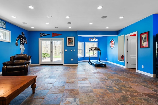 interior space featuring baseboards, a chandelier, and plenty of natural light