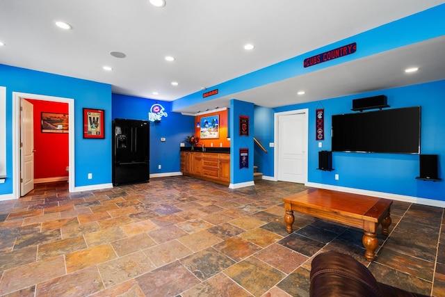 living area with recessed lighting, indoor wet bar, stone tile floors, and baseboards