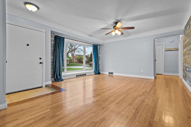 foyer entrance with ceiling fan, visible vents, and wood finished floors