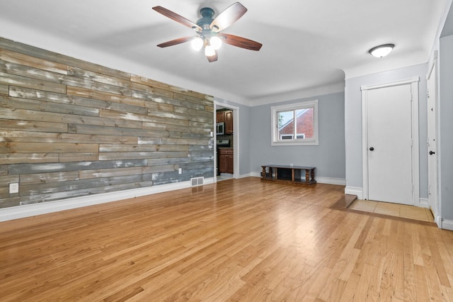 unfurnished room featuring baseboards, ceiling fan, light wood-type flooring, and visible vents