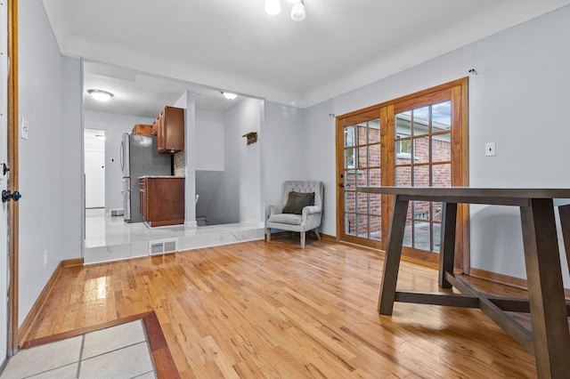 unfurnished room featuring visible vents, light wood-style flooring, and baseboards