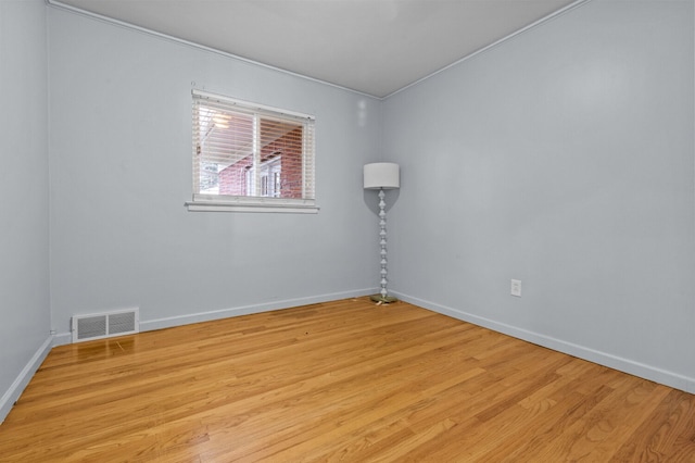 empty room featuring visible vents, baseboards, and light wood-type flooring