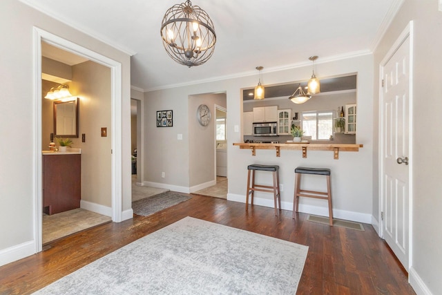 interior space featuring glass insert cabinets, stainless steel microwave, a breakfast bar, dark wood-style flooring, and a peninsula