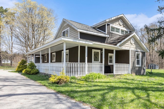 view of front of property featuring a porch, a front yard, and roof with shingles