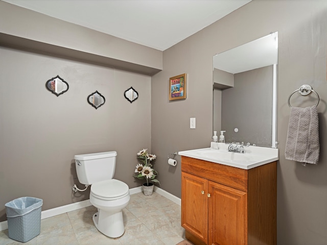 bathroom featuring vanity, baseboards, toilet, and tile patterned flooring