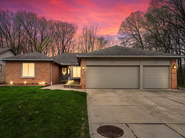 view of front of house featuring roof with shingles, an attached garage, a front lawn, brick siding, and concrete driveway