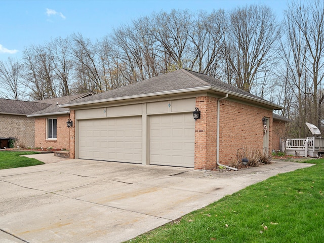 view of side of property with brick siding, an attached garage, roof with shingles, and concrete driveway