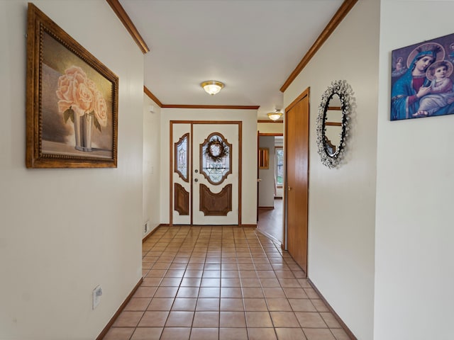 doorway featuring crown molding, baseboards, visible vents, and light tile patterned floors