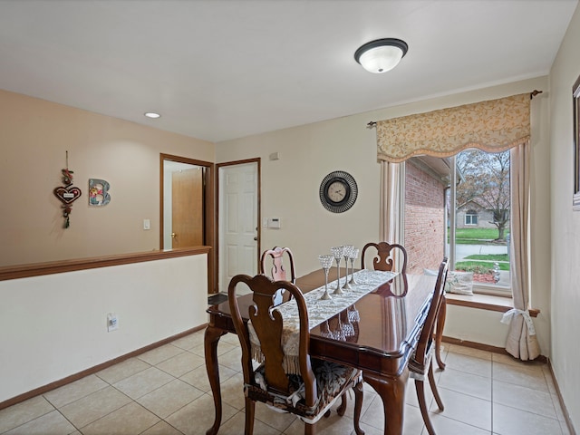 dining space with baseboards and light tile patterned flooring