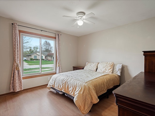 bedroom with baseboards, ceiling fan, and wood finished floors