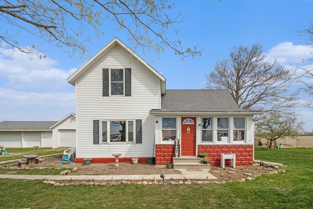 traditional home with a front lawn, a garage, and a shingled roof