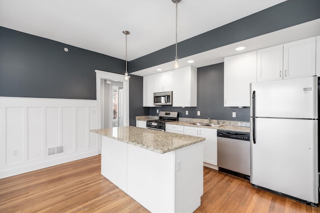 kitchen with visible vents, appliances with stainless steel finishes, light wood-style flooring, a sink, and white cabinetry