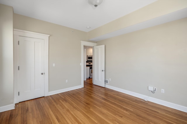unfurnished bedroom featuring baseboards, visible vents, and light wood-type flooring