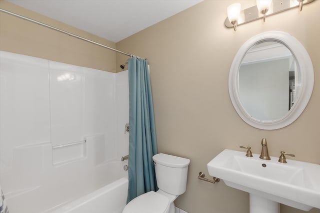 bathroom featuring toilet, a sink, and shower / bath combo
