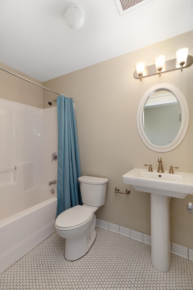bathroom featuring toilet, tile patterned floors, shower / bath combo with shower curtain, baseboards, and visible vents