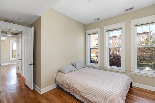 bedroom featuring baseboards, visible vents, and hardwood / wood-style flooring