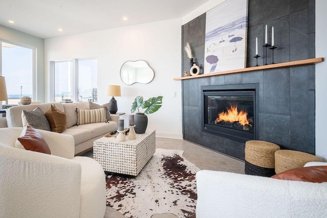 living area featuring recessed lighting, baseboards, wood finished floors, and a fireplace