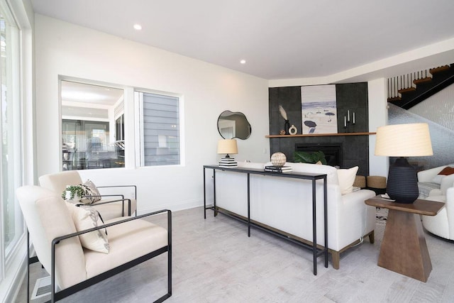 interior space featuring baseboards, a fireplace, recessed lighting, and wood finished floors