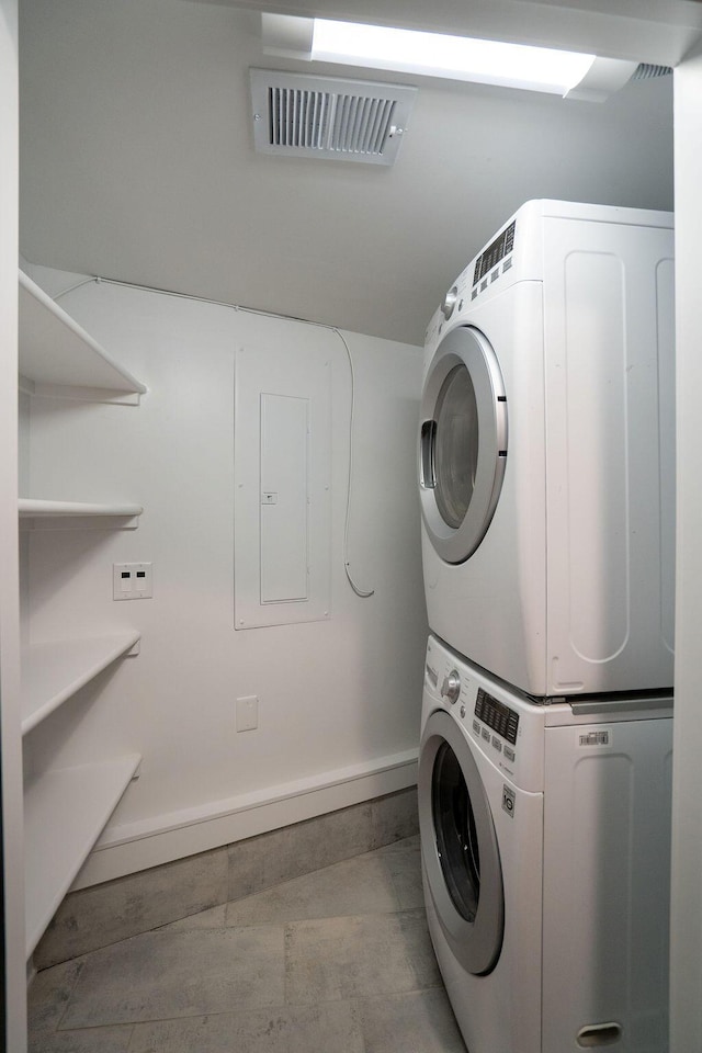 laundry area featuring baseboards, laundry area, stacked washer / drying machine, and visible vents