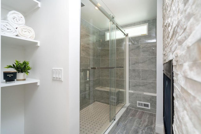 bathroom featuring a fireplace, visible vents, and a stall shower