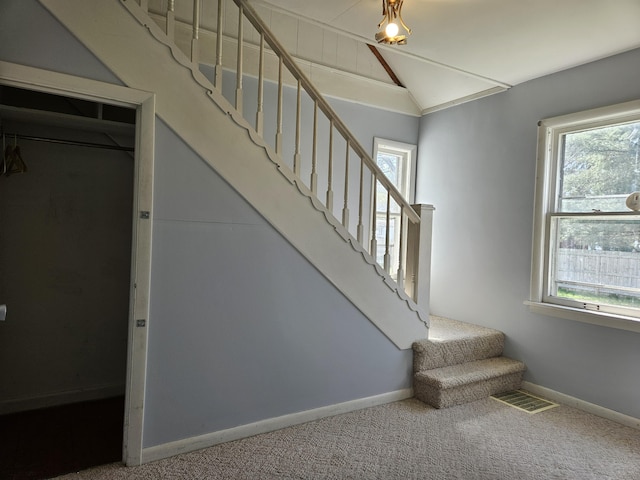 9 W Michigan St, Three Oaks, MI 49128 - staircase featuring visible vents, baseboards, vaulted ceiling, and carpet floors