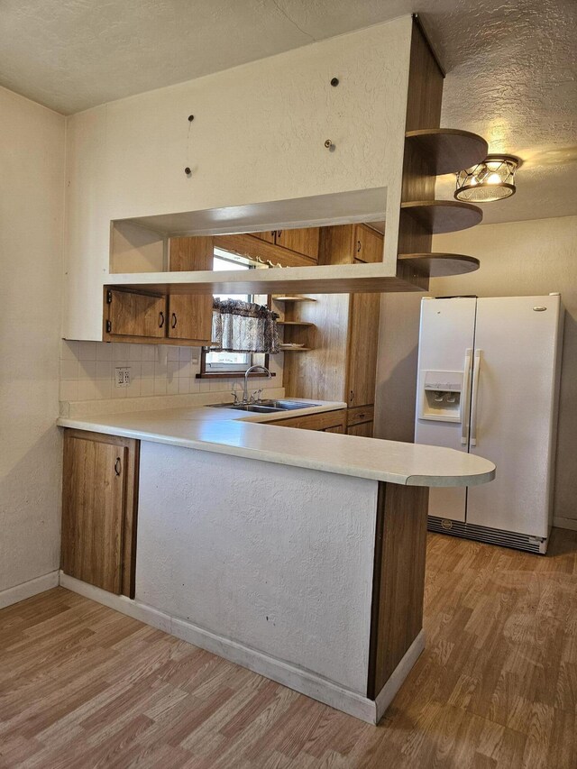 9 W Michigan St, Three Oaks, MI 49128 - kitchen with white fridge with ice dispenser, open shelves, and brown cabinets