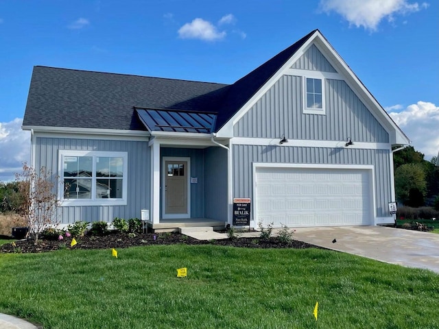 view of front facade with a front lawn, a standing seam roof, a shingled roof, driveway, and board and batten siding