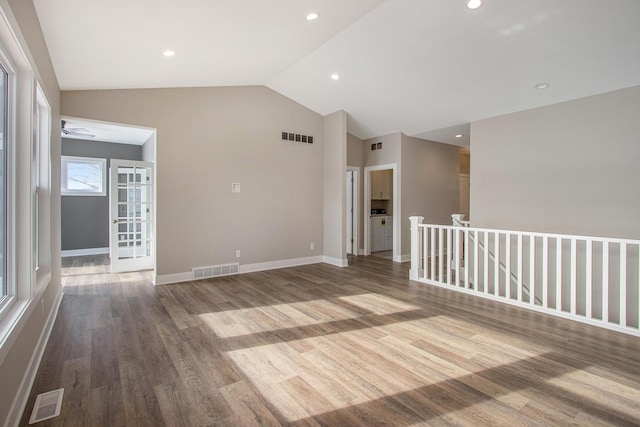 unfurnished room featuring visible vents, wood finished floors, and lofted ceiling