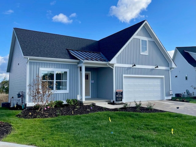 modern farmhouse with concrete driveway, a front lawn, board and batten siding, and a shingled roof