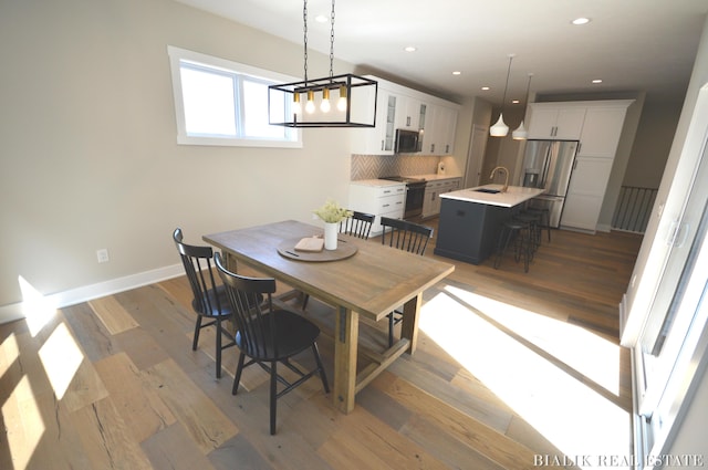dining room with light wood finished floors, recessed lighting, and baseboards
