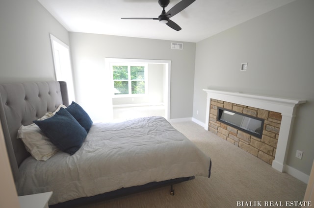 carpeted bedroom with visible vents, baseboards, ceiling fan, and a fireplace