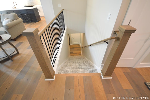 stairs with wood finished floors and baseboards