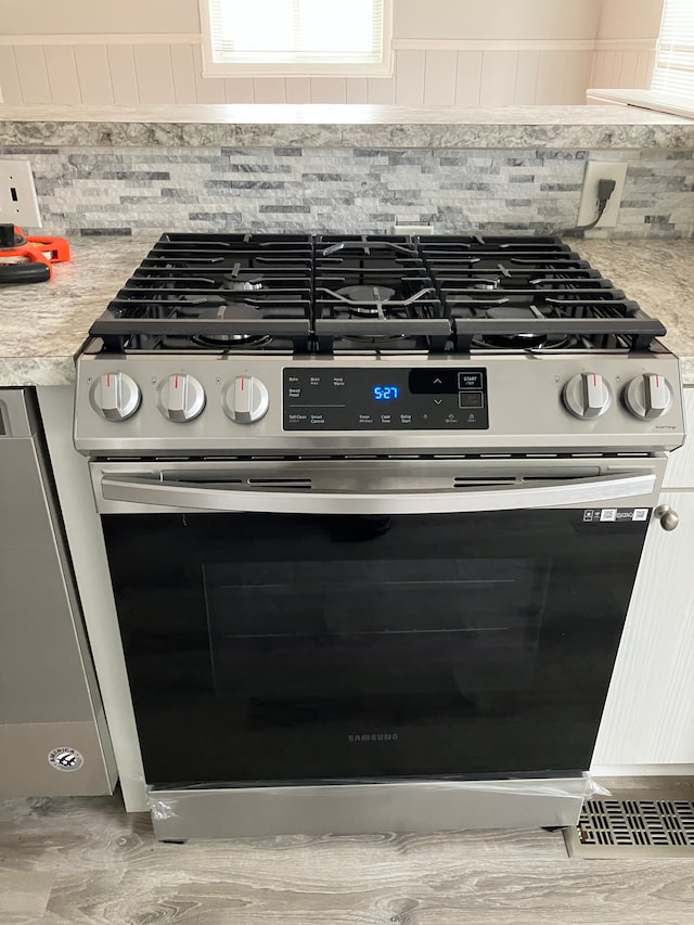 1271 Featherstone Rd, Pontiac, MI 48342 - interior details with stainless steel gas range, light countertops, and tasteful backsplash