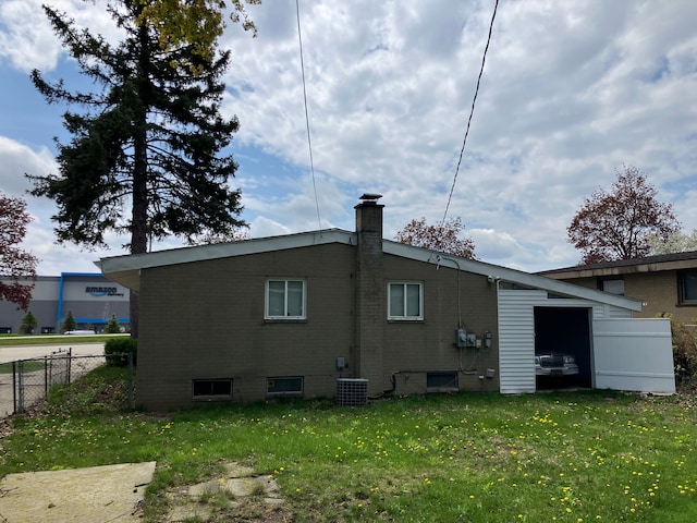 1271 Featherstone Rd, Pontiac, MI 48342 - rear view of house featuring a yard, fence, a chimney, and central AC
