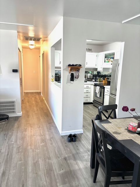 kitchen featuring stainless steel appliances, light wood-type flooring, visible vents, baseboards, and white cabinets